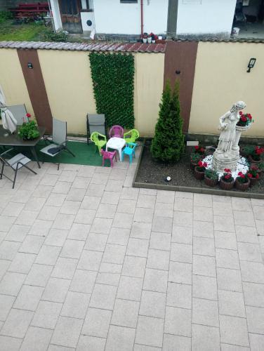a patio with a statue and tables and chairs at Izabella Guest House in Săcele