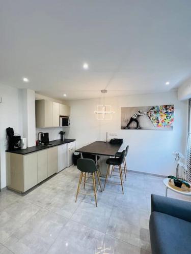 une cuisine et un salon avec une table et des chaises dans l'établissement L'écrin - 4 pers - Neuf - Hyper centre - Plage à 2 min à pied, à Saint-Raphaël