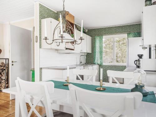a dining room with white chairs and a table at Holiday Home Smultronstället by Interhome in Stavsnäs