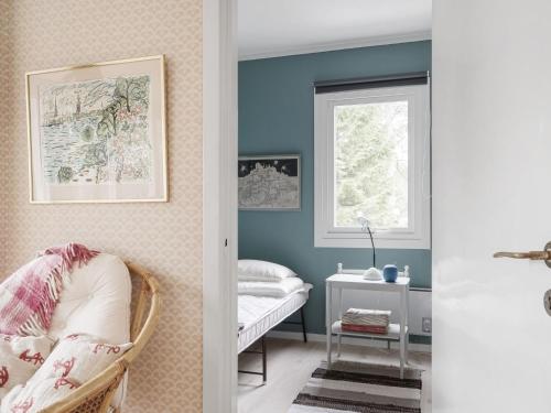 a room with blue walls and a chair and a window at Holiday Home Smultronstället by Interhome in Stavsnäs