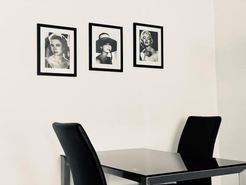 Le Suquetan في كان: طاولة غرفة طعام مع أربعة صور على الحائط