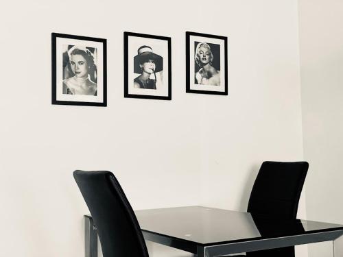 a dining room table with four pictures on the wall at Le Suquetan in Cannes