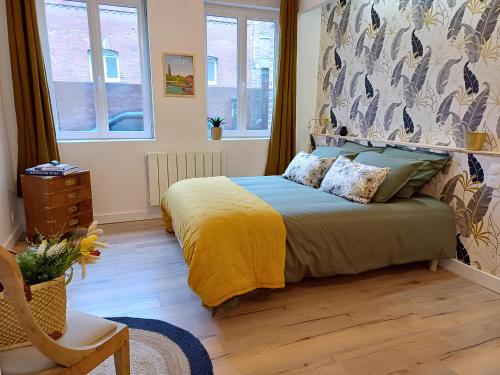 une chambre avec un lit avec une couverture jaune dans l'établissement Pause amiénoise - Proche centre ville - wifi Fibre, à Amiens