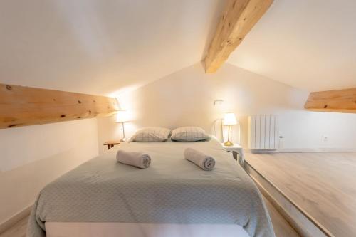 a white bedroom with a large bed with two pillows at Olive- Vaste appartement donnant sur la Sorgue in LʼIsle-sur-la-Sorgue