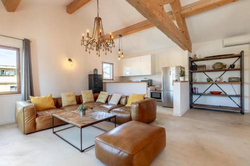 a living room with a couch and a table at Olive- Vaste appartement donnant sur la Sorgue in LʼIsle-sur-la-Sorgue