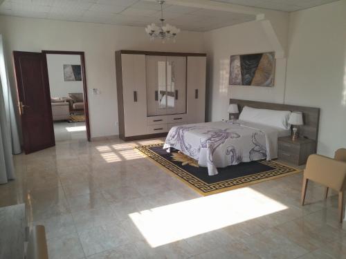 - une chambre avec un lit et un chien posé sur un tapis dans l'établissement Hotel elik obuc, à Mongomo