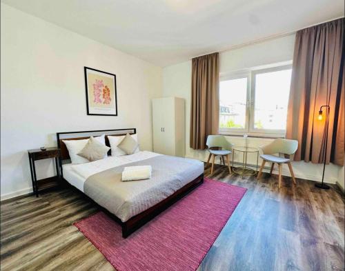 a bedroom with a large bed and a pink rug at Zentral gelegenes und stilvoll möbliertes Apartment in Duisburg Nur 5 Minuten vom Hbf und City, ideal für Pendler und Messebesucher in Duisburg