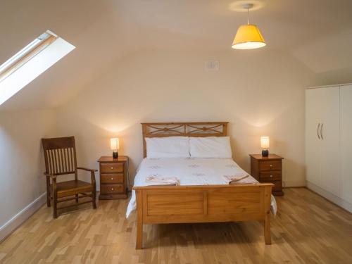 een slaapkamer met een bed, een stoel en verlichting bij 17 Canons Lane in Clifden