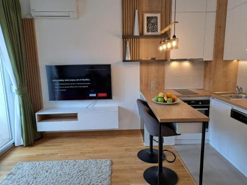 a kitchen with a table with a bowl of fruit on it at Marina City key Luxury Studio in Podgorica
