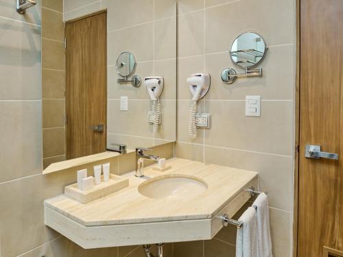 y baño con lavabo y espejo. en Estelar Apartamentos Bellavista, en Lima
