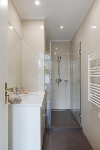 a bathroom with a glass shower and a sink at Santa Maria Rooms and Apartments in Setúbal