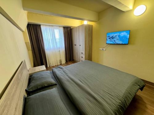 a bedroom with a large bed and a tv on the wall at Arshakunyats 88 TopHouse in Yerevan