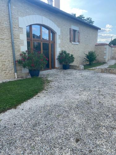 a house with two potted plants in front of it at Clos de Joco - Gîte de groupe in Pas-de-Jeu