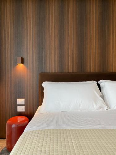 a bedroom with a white bed and a red stool at Le Stanze del Lago Lake View in Como