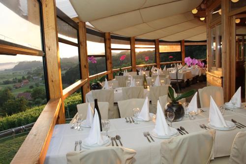 a dining room with white tables and white chairs at Pansion Rody in Gornja Stubica