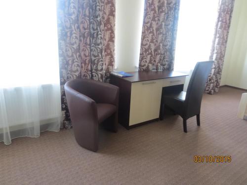 a desk and two chairs in a hotel room at Mіnі Gotel Pozitiv in Horodets'ke