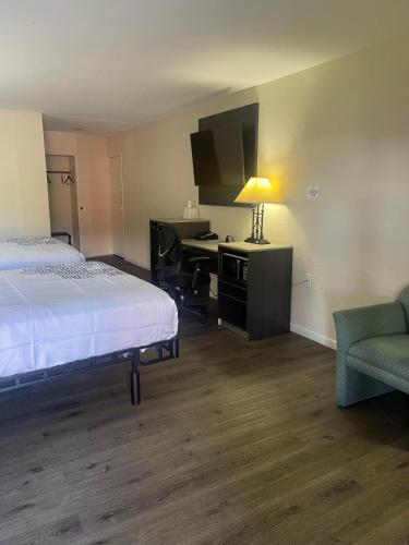 バーズタウンにあるBourbon Capital Innのベッドと机と椅子があるホテルの部屋