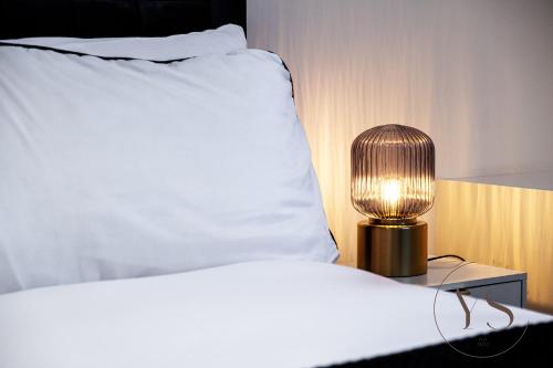 un lit avec une lampe sur une table à côté d'un lit dans l'établissement Stylish Studio 3 - City Centre Coach Station, à Birmingham