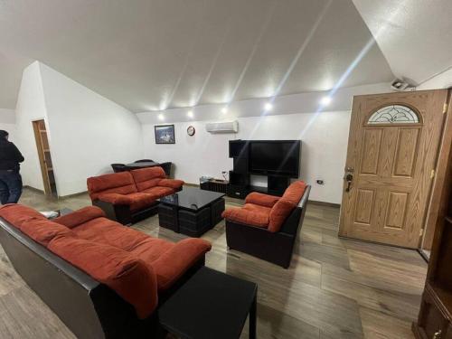 a living room with couches and a flat screen tv at GR20acd Mary in Cuauhtémoc