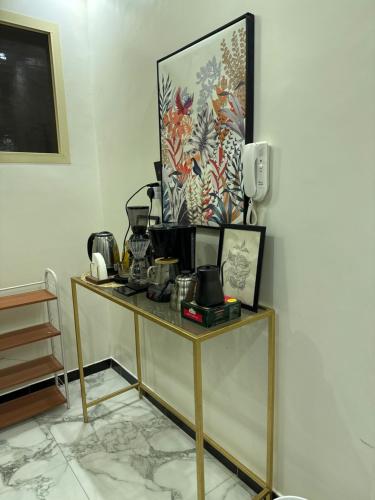 einen Tisch in einem Zimmer mit einem Bild an der Wand in der Unterkunft شقة خاصة بغرفتي نوم ومطبخ وصالة ومجلس in Unaizah