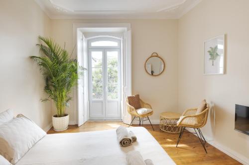 a bedroom with a bed and a table and chairs at Santa Maria Rooms and Apartments in Setúbal
