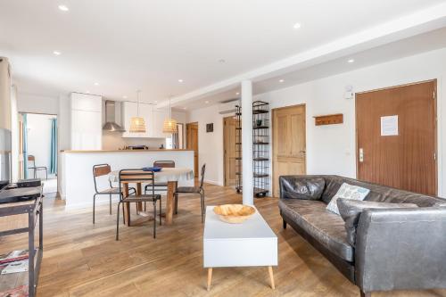 un salon avec un canapé et une table dans l'établissement Raisin- appartement familial donnant sur la Sorgue, à LʼIsle-sur-la-Sorgue