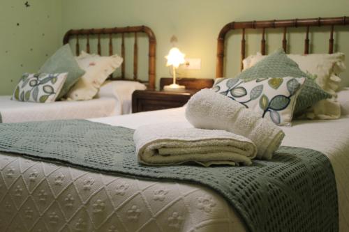 1 dormitorio con 2 camas y toallas en la cama en La Cuadra I en La Pola de Gordón