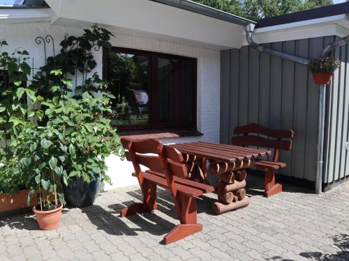 a picnic table and two benches on a patio at Ferienwohnung Carstens in Itzehoe
