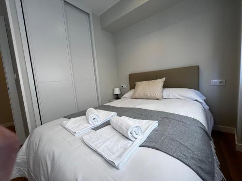 a bedroom with a bed with towels on it at A Terraza By Oktheway in Laxe
