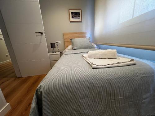 a bed with two towels on it in a room at A Terraza By Oktheway in Laxe