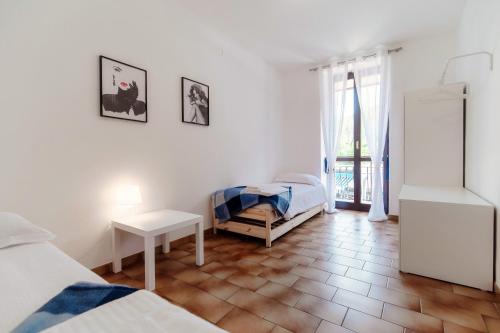 1 dormitorio con 2 camas, mesa y ventana en ORTENSIA APARTMENT, en Bellagio