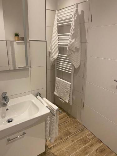 a bathroom with a sink and a shower and towels at Moderne Ferienwohnung Meerestraum in Dangast in Varel