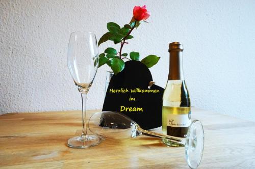 una botella de vino, un vaso y una flor en Ferienwohnung An der Dorfmauer, en Sommerach