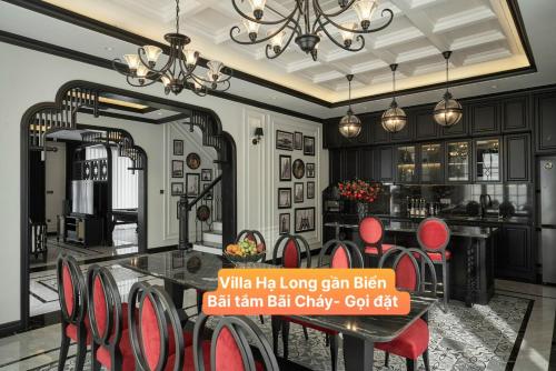 a dining room with a table and red chairs at Villa Hạ Long Gần Biển in Ha Long
