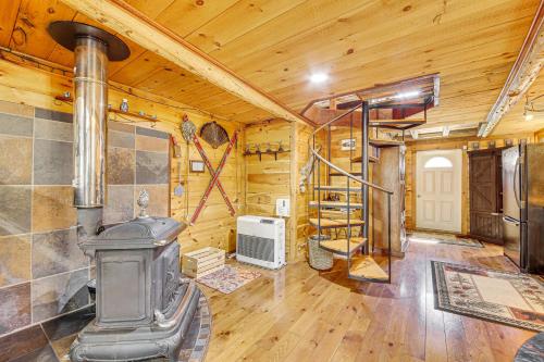 een woonkamer met een houtkachel in een hut bij Rustic Searsport Cabin Loft and Sunroom on 10 Acres in Searsport