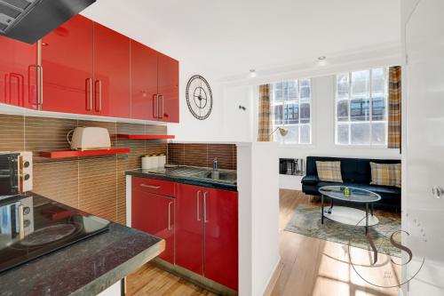 une cuisine avec des placards rouges et une table dans l'établissement Stylish Studio 4 - City Centre Coach Station, à Birmingham