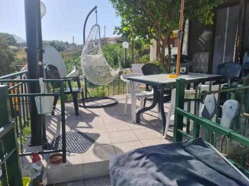 un patio con mesa, sillas y una valla en villino giulia, en Villammare