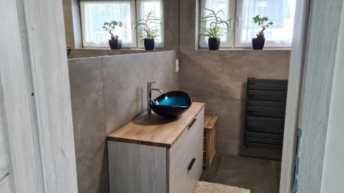 a bathroom with a bowl sink on a wooden counter at Piękny Dom blisko morza in Gdynia