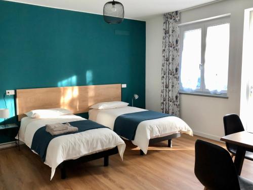 2 camas en una habitación con una pared verde en Roggia Maestra B&B, en Schio