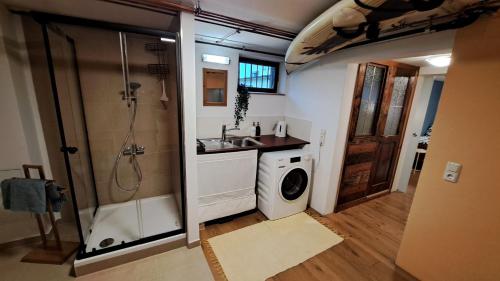 a bathroom with a shower and a sink and a washing machine at Ferienwohnung Bär Außerbraz in Innerbraz