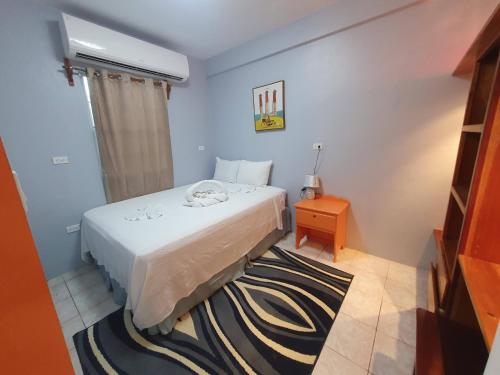 a small bedroom with a bed and a small table at Rachel Land in Caye Caulker