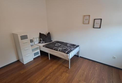 a small bedroom with a bed and a dresser at Ferienwohnung Paulus in Albstadt