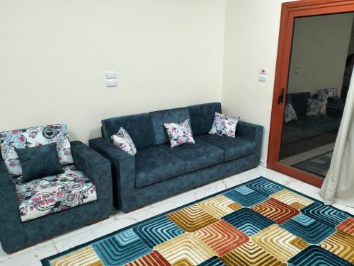 sala de estar con sofá azul y silla en شقه رائعه بأفضل اطلاله, en Luxor