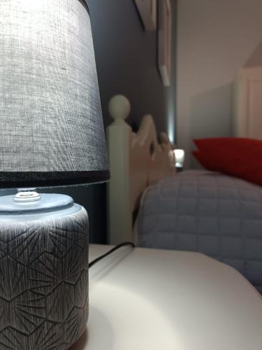 a lamp sitting on a table next to a bed at CASA DIDYMA in San Giovanni Gemini