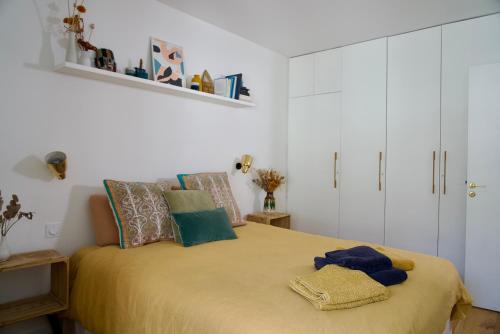 une chambre avec un grand lit avec une couverture jaune dans l'établissement Superbe appartement lumineux proche du Marais, à Paris
