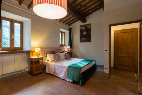 een slaapkamer met een groot bed en een lamp bij LE FONTI di SAN GIMIGNANO ROOM in San Gimignano