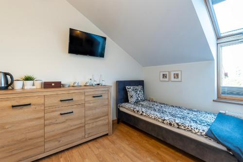 a bedroom with a bed and a dresser at Medical Spa Kwiatowa in Łęczyca