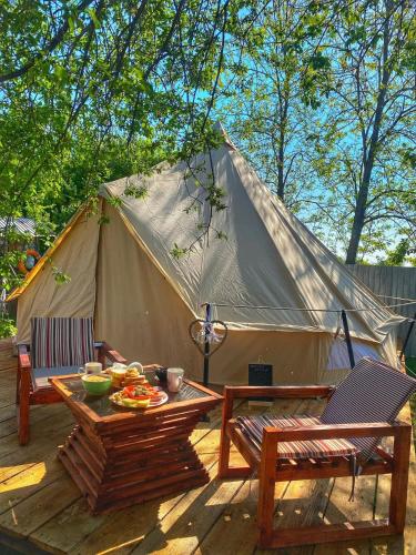 a tent with a table and chairs in front of it at Delta Dunarii - Casa de langa apa in Ilganii de Sus