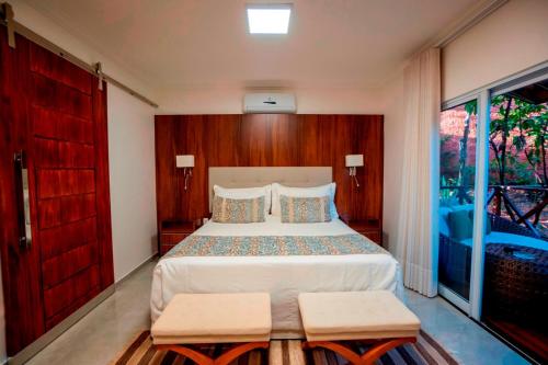a bedroom with a large bed and a large window at Ananda Pousada in Pirenópolis