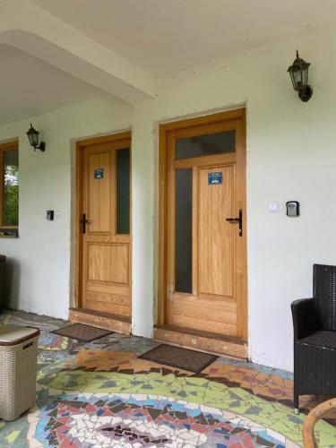 duas portas de madeira num quarto com um tapete em Atlantis Home em Kulen Vakuf